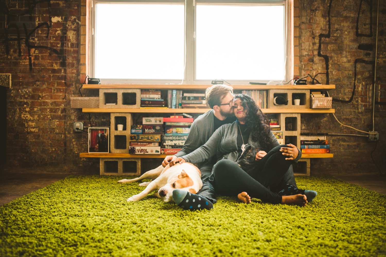 Candid moment of engaged couple with their dogs during at-home session in downtown San Antonio