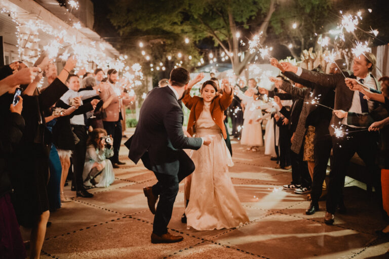 Couple dancing whole exiting their wedding at night