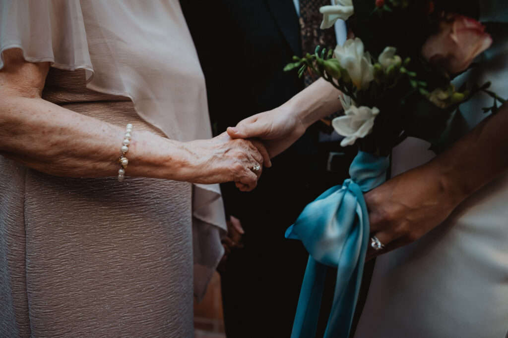 Detail of a couple holding hands with the bridal bouquet, documentary wedding photo by San Antonio photographer Christian Margain
