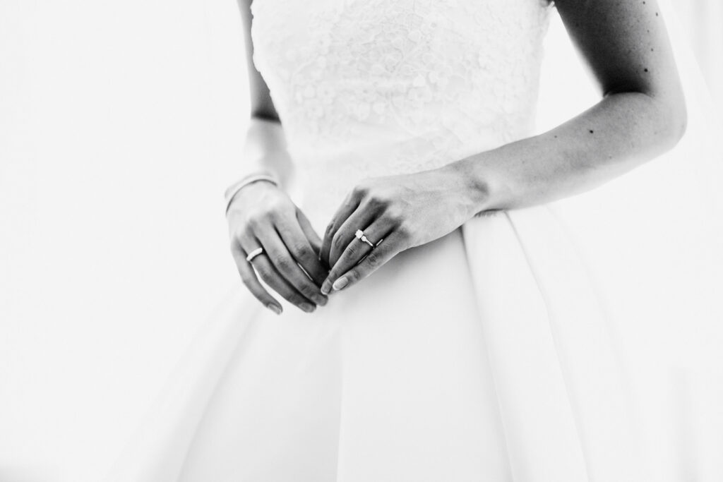 Bride's hands and wedding ring against her dress, award-winning documentary detail by San Antonio wedding photographer Christian Margain